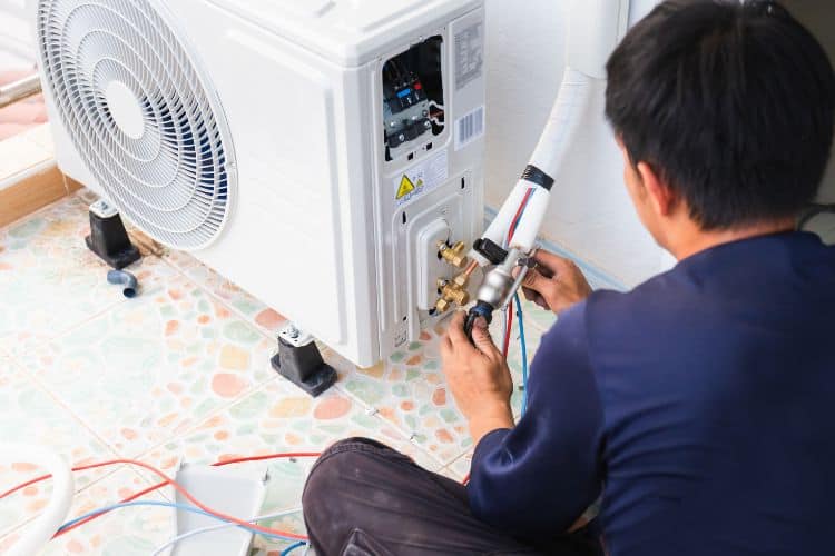 Air Conditioning Technician Installing a Compressor Unit