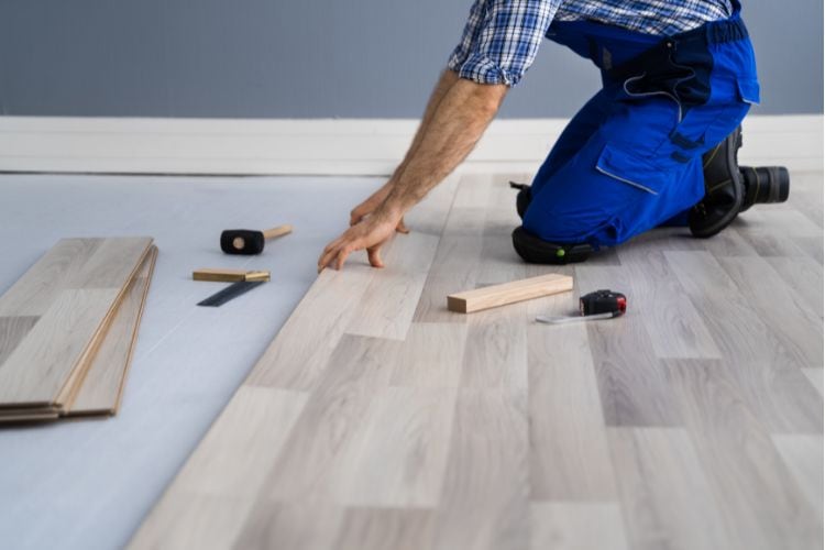 Construction Worker Doing Hardwood Floor Laminate Renovation